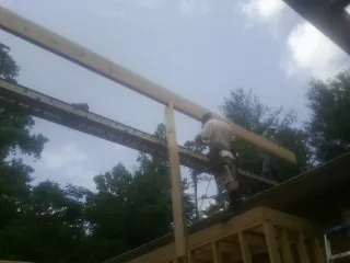 Carpenter setting a ridge beam over a new addition frame — Ice Dam Removal by Roofing Brothers in Los Altos
