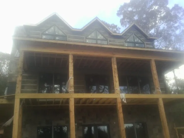 Dormers and porch framing on a large log home under construction — Roof Coating work by our crew in Los Altos