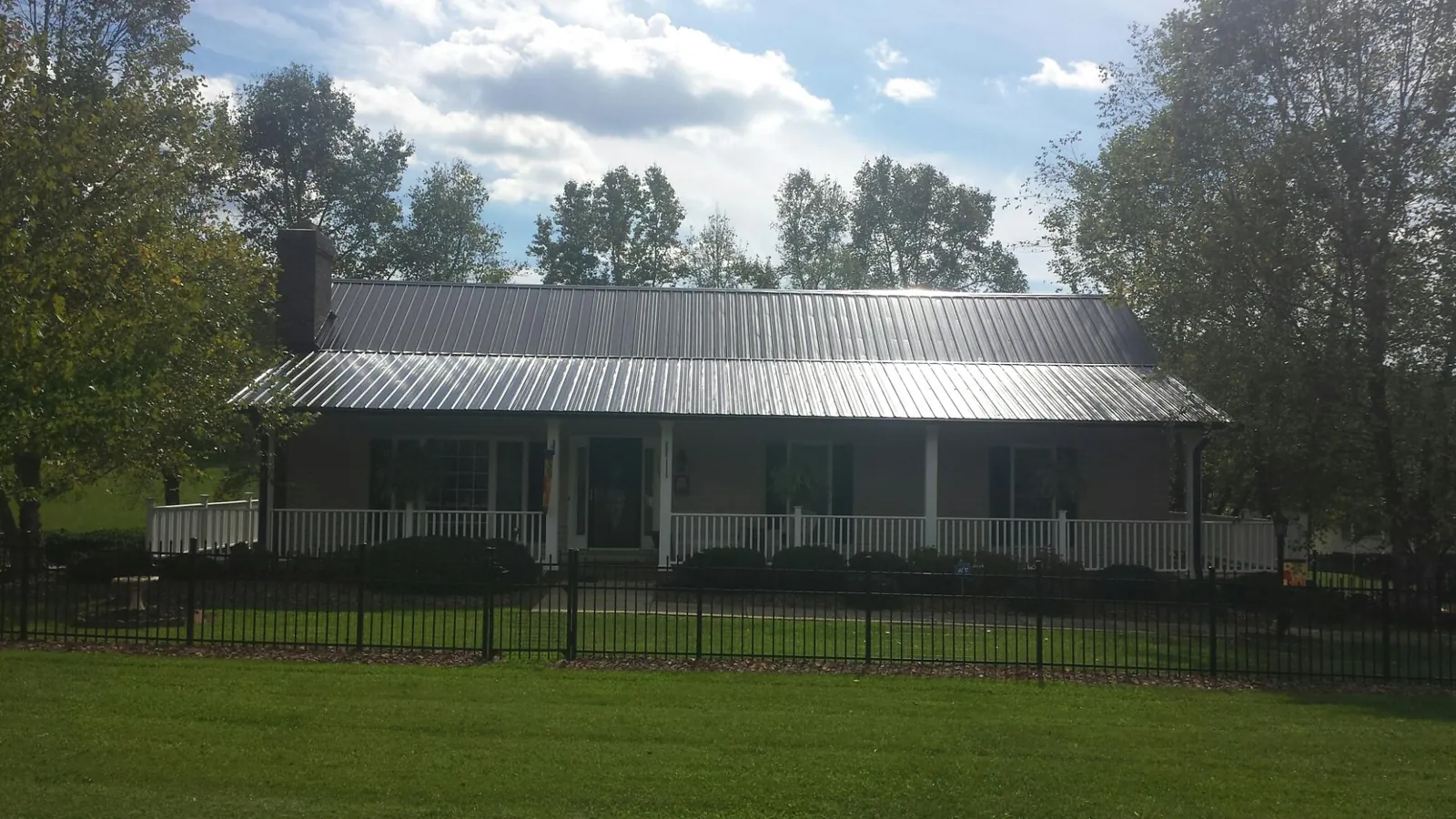 Gray metal roof on a brick ranch with a full width front porch — Gutter Guard Installation work by our crew in Los Altos